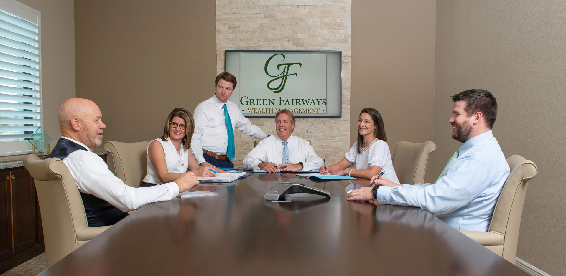 The Green Fairways Wealth Management team sitting around a conference room table